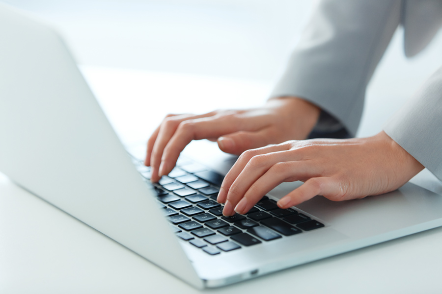 Image of womans hands on laptop keyboard
