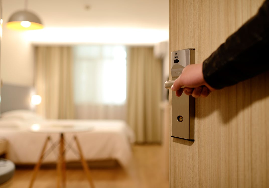 Person opening the door to a hotel room